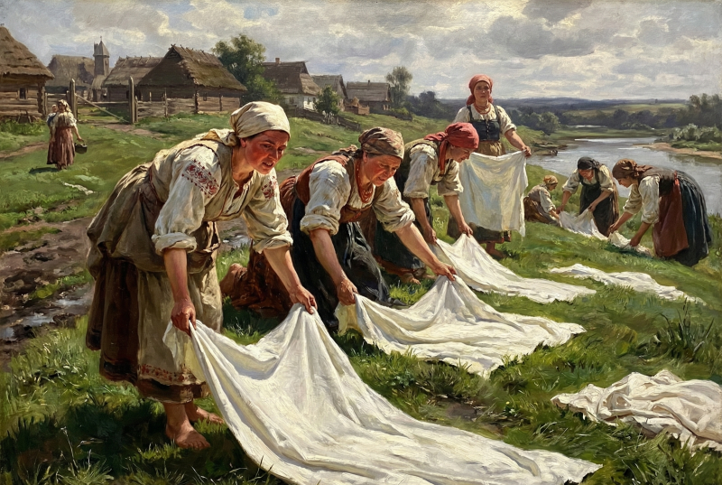 A group of people gathering and organizing laundry in an open field.